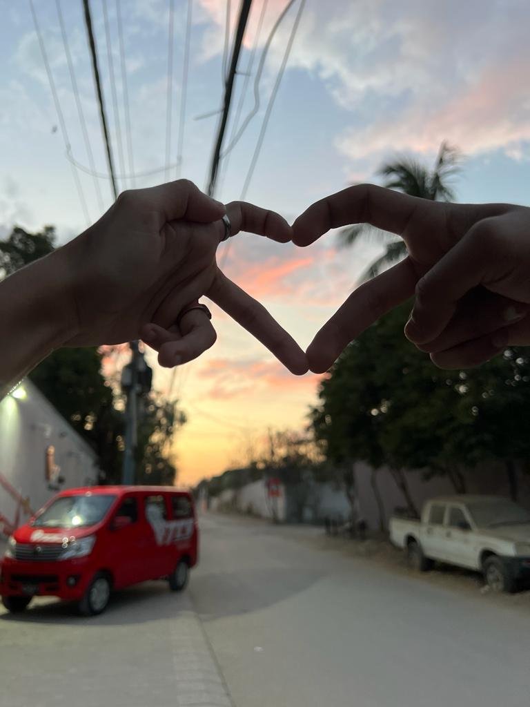 Hands making a heart shape at sunset